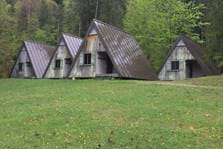 Idyllisch liegen die Zelthütten aus Holz zwischen südlichen Walchenseeufer und Waldrand